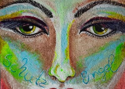 Ausdrucksstarkes Acrylporträt eines Gesichts mit intensivem Blick und farbigen Akzenten, auf den Wangen die Worte „Schutz“ und „Engel“, symbolisch für innere Begleitung.